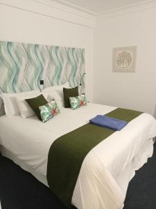 ein Schlafzimmer mit einem großen weißen Bett mit vier Kissen in der Unterkunft Mediterrâneo Madeira in São Vicente