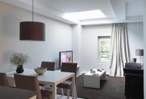 a white living room with a table and chairs at Rambla 102 in Barcelona