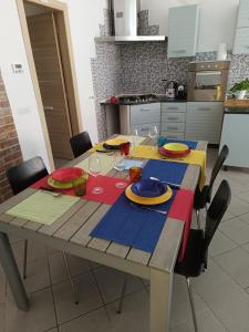 stół z talerzami i okularami w kuchni w obiekcie KuneKune MONOLOCALE w mieście Albissola Marina