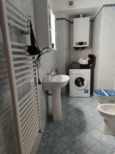 łazienka z umywalką i pralką w obiekcie KuneKune MONOLOCALE w mieście Albissola Marina