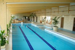 a large swimming pool in a building at Hotel Lycium Debrecen in Debrecen