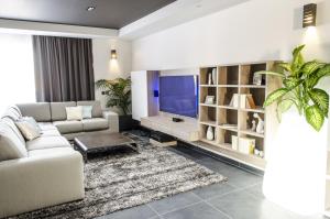 a living room with a couch and a tv at Paramount Bay Penthouse in Birżebbuġa