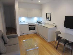 a kitchen with white cabinets and a table and a couch at Stylish City Apartment in Edinburgh