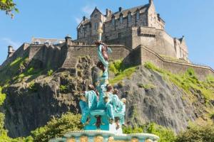 a statue in front of a castle at Stylish City Apartment in Edinburgh