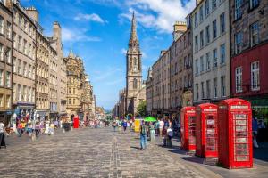 a city street with red phone booths and a clock tower at Stylish City Apartment in Edinburgh