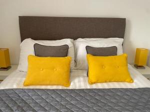 a bed with two yellow pillows on it at Flat 1 High Street Apartments, One Bed in Wellington