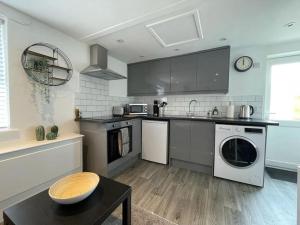 a kitchen with a sink and a dishwasher at Flat 1 High Street Apartments, One Bed in Wellington