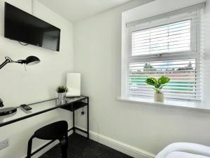 a white room with a desk and a window at Flat 1 High Street Apartments, One Bed in Wellington