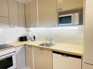 a kitchen with a sink and a microwave at Cityhome Kaarto in Rovaniemi