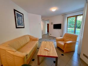 una sala de estar con un sofá y una mesa en Ferienwohnung BAYERNRING, en Breitenbrunn