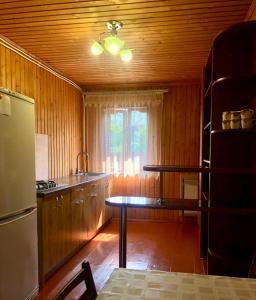 a kitchen with wooden walls and a table and a window at Садиба Анастасія in Sheshory