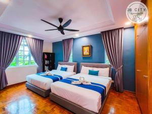 two beds in a bedroom with blue walls at JB Town Villa by JBcity Home in Johor Bahru