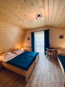 a bedroom with two beds and a table in it at Agroturystyka SKALNE in Szczawa