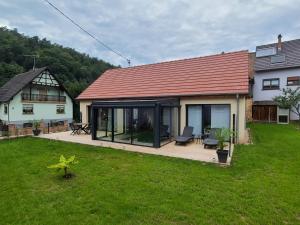 a house with a deck and a house with a red roof at Au p'tit bonheur in Rothbach