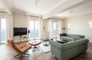 een woonkamer met een bank en een tv bij #Primavera: Seafront apt with White tower view in Thessaloniki
