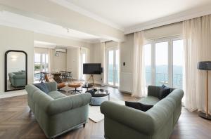 een woonkamer met 2 banken en een tafel bij #Primavera: Seafront apt with White tower view in Thessaloniki
