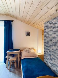 - une petite chambre avec un lit et une table dans l'établissement Agroturystyka SKALNE, à Szczawa