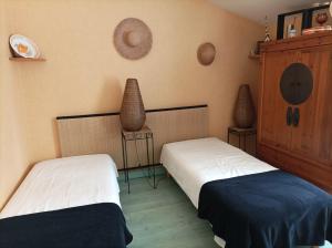 Dos camas en una habitación con dos jarrones en la pared en Chez Pierre et Caroline, en Les Herbiers 13 fotos más