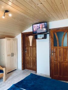 a tv on the wall in a room with doors at Agroturystyka SKALNE in Szczawa