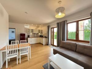 salon z kanapą i stołem w obiekcie Apartament z ogrodem w Sarbinowie