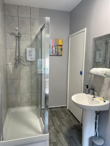 a bathroom with a shower and a sink at Alexander Hotel Whitley Bay in Whitley Bay