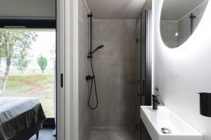 a bathroom with a shower and a sink at Aera - Glass cabins in Tromsø