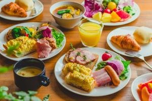 a wooden table with plates of breakfast foods and drinks at La'gent Stay Sapporo Odori Hokkaido in Sapporo