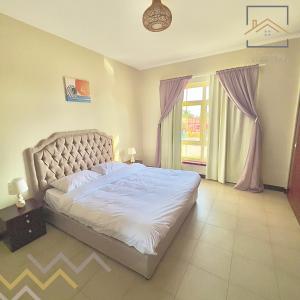 um quarto com uma cama grande e uma janela em بِيُوتات الرّفآه - أناقة المرينا em King Abdullah Economic City