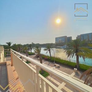 uma vista para um corpo de água com palmeiras em بِيُوتات الرّفآه - أناقة المرينا em King Abdullah Economic City