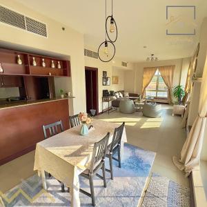 uma sala de jantar e sala de estar com mesa e cadeiras em بِيُوتات الرّفآه - أناقة المرينا em King Abdullah Economic City