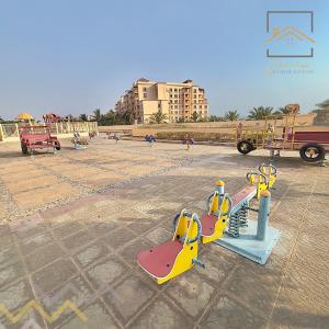 a playground with a slide in a park at بِيُوتات الرّفآه - أناقة المرينا in King Abdullah Economic City
