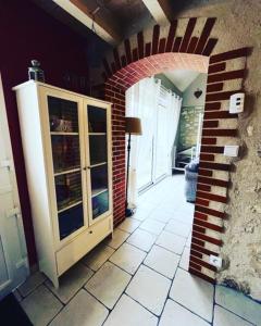 a room with a brick wall and a glass cabinet at Gite de la Pilaudière in Thésée +6 photos