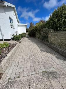 un vialetto di mattoni di fronte a una casa bianca di Bjergby Sønderbo feriehus a Bjergby