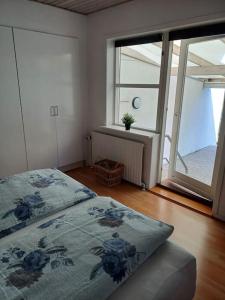 a bedroom with a bed and a large window at Bjergby Sønderbo feriehus in Bjergby