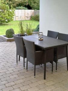 einen Holztisch und Stühle auf einer Terrasse in der Unterkunft Bjergby Sønderbo feriehus in Bjergby