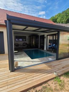 a pool house extension with a deck and a swimming pool at Au p'tit bonheur in Rothbach