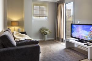a living room with a couch and a flat screen tv at Rambla 102 in Barcelona