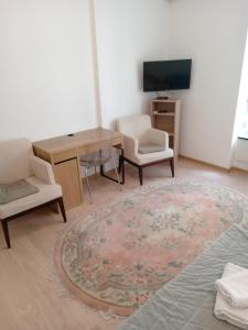 sala de estar con mesa, 2 sillas y TV en City Apartments Ana, en Belgrado
