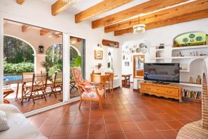 a living room with a television and a dining room at N'Antiga in Sant Lluis