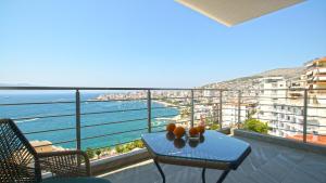 a table on a balcony with a view of the ocean at Blue Eye Apartment in Sarandë