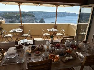 a dining room with a table with a view of the ocean at Entre Ciel et Mer in Bonifacio