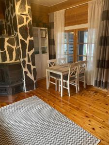 ein Esszimmer mit einem Tisch, Stühlen und einem Kamin in der Unterkunft Cityvilla on the shore of Lake Haapajärvi in Joensuu