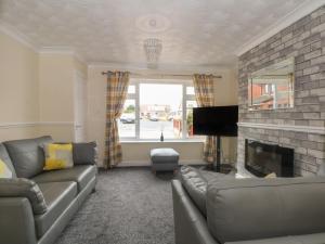 a living room with a couch and a fireplace at Coed Bach in Prestatyn