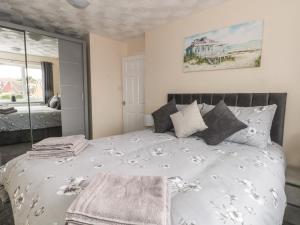a bedroom with a large bed with a large window at Coed Bach in Prestatyn