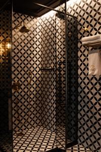 a bathroom with a shower with black and white tiles at Mandarin Club House in Batumi