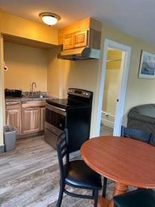 a kitchen with a table and a table and a dining room at Swiss Chalets Village Inn in North Conway