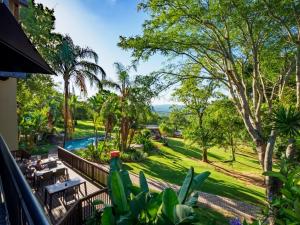 uma vista para a piscina a partir da varanda de uma casa em Umbhaba Eco Lodge em Hazyview