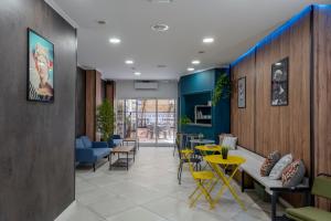 SOM Hostel By The Venue في فالنسيا: غرفة انتظار مع طاولات وكراسي صفراء