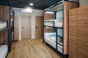 a room with four bunk beds and wooden cabinets at SOM Hostel By The Venue in Valencia