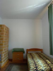 ein kleines Schlafzimmer mit einem Bett und einem Stuhl in der Unterkunft Leśniczówka Turowo - Podlasie 